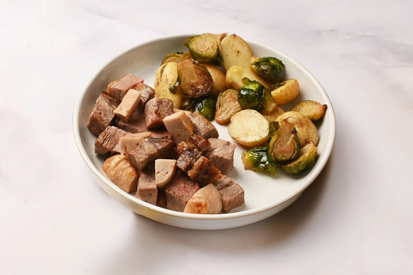 Picaña y salchicha blanca acompañada de verduras rostizadas