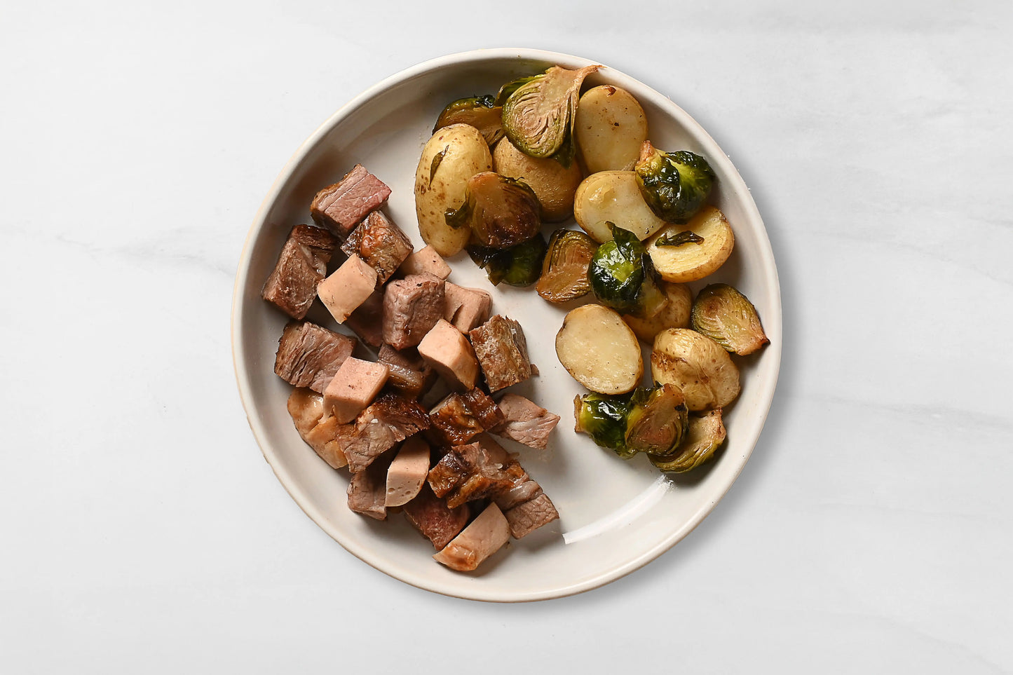 Picaña y salchicha blanca acompañada de verduras rostizadas