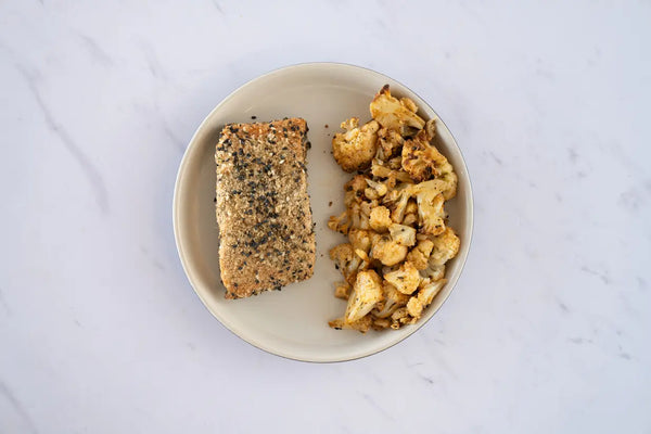 Salmón con costra de ajonjolí y coliflor rostizada